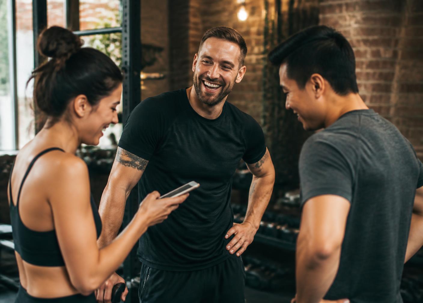 An instructor laughing with two students who stayed behind after class